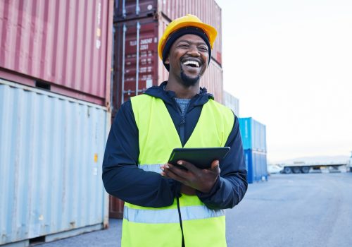 Logistics, tablet and black man planning shipping of container with stock on technology at a port.
