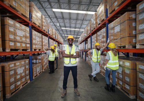 Warehouse workers checking inventory in a large distrubiton warehouse.